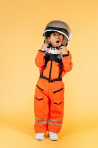 Amazed boy in orange astronaut suit